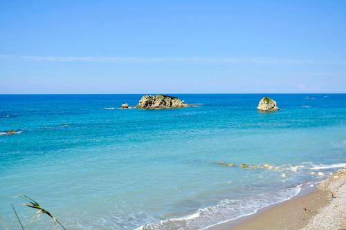 a beach with some rocks in the water at Maria in Ágios Matthaíos