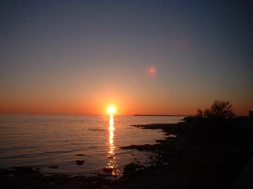 a sunset over the ocean with the sun setting at Casa Dalfea in Mazara del Vallo