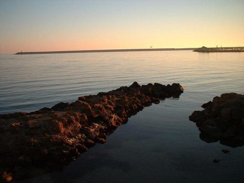 a group of rocks in the water at sunset at Casa Dalfea in Mazara del Vallo