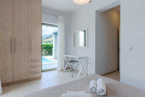 普拉基亞斯的住宿－普拉基亞斯度假酒店，一间卧室配有一张床、一张书桌和一个窗户。