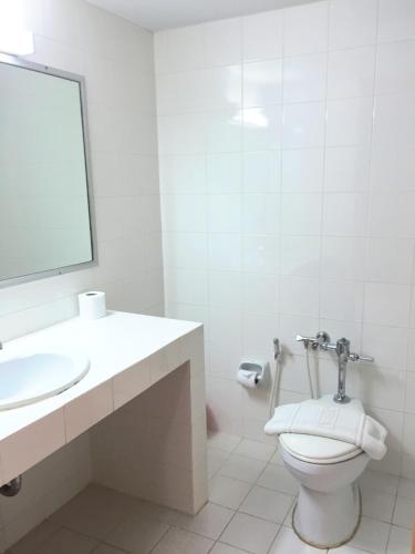 a bathroom with a toilet and a sink and a mirror at Takiab Beach Resort in Hua Hin