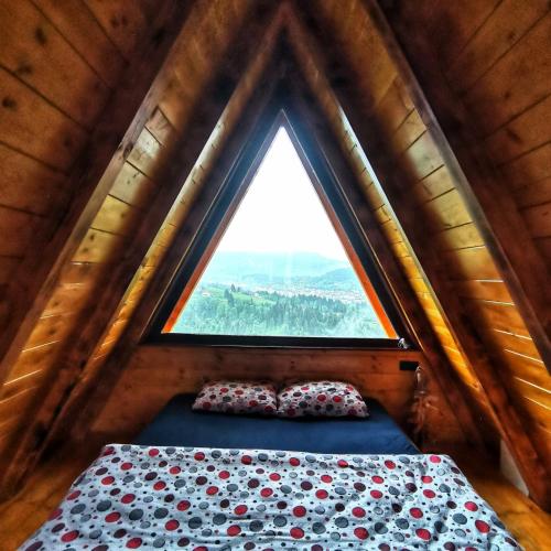 a bedroom in a tree house with a window at Vikendica Tromedja Pale in Pale