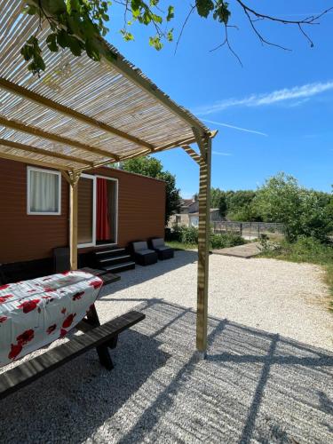 a patio with a pergola and a bed at Le Murmont in Thonnance-lès-Joinville