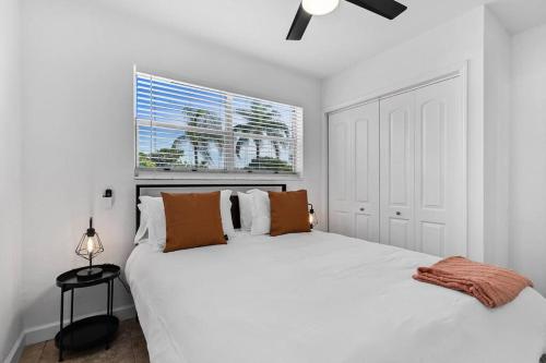 a white bedroom with a large white bed and a window at Bright 3 bedrooms Home Private Pool, 18 minutes to the Ocean in Hollywood