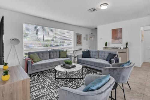 a living room with two couches and a table at Bright 3 bedrooms Home Private Pool, 18 minutes to the Ocean in Hollywood