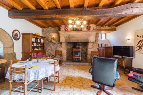 une salle à manger avec une table et une cheminée dans l'établissement Manoir 16ème siècle Proche Paimpol, à Pommerit-le-Vicomte