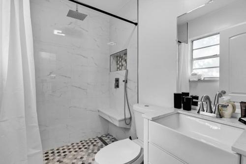 a white bathroom with a toilet and a shower at Bright 3 bedrooms Home Private Pool, 18 minutes to the Ocean in Hollywood