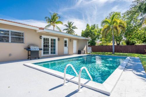 a swimming pool in front of a house at Bright 3 bedrooms Home Private Pool, 18 minutes to the Ocean in Hollywood