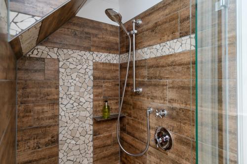 a bathroom with a shower with a wooden wall at Hotel Parkresidenz Christian VIII in Archsum