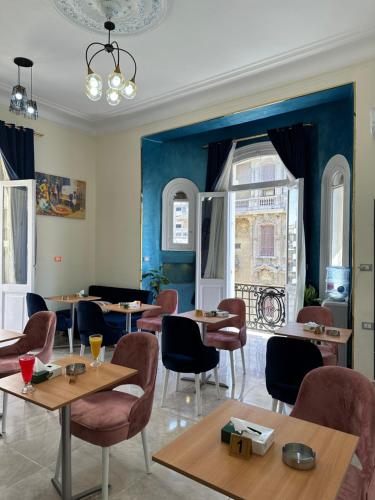 ein Restaurant mit Tischen und Stühlen und blauen Wänden in der Unterkunft Victory Of Downtown Hotel in Kairo
