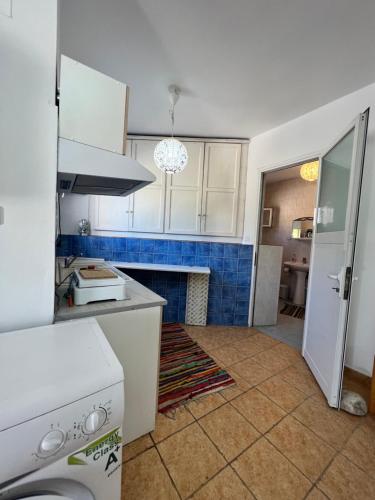 a kitchen with white cabinets and a fireplace at Beach House LIPSI Island (Katsadia Beach) in Lipsoi
