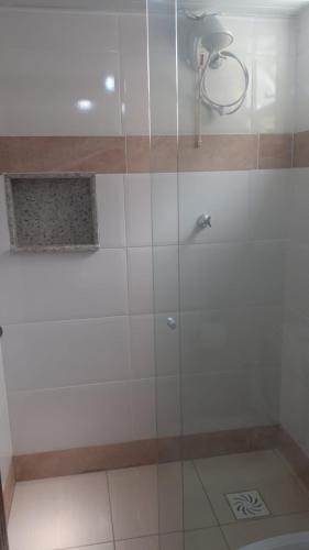 a shower with a glass door in a bathroom at Pousada Bangalôs Da Mole - Florianópolis in Florianópolis
