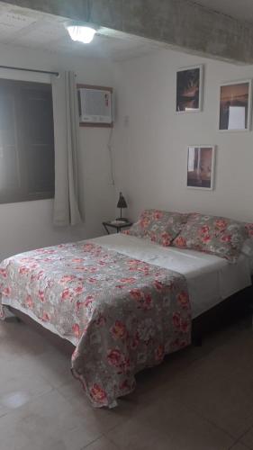 a bedroom with a bed with a floral bedspread at Pousada Bangalôs Da Mole - Florianópolis in Florianópolis