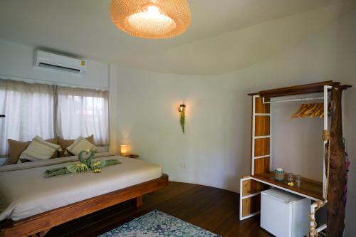 a bedroom with a large bed and a window at Ocean Vibes in Thongsala
