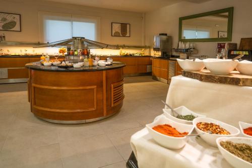 a kitchen with a counter with bowls of food at CNic Gemini Hotel in Mesongi