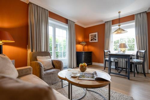 a living room with a couch and a table at Hotel Parkresidenz Christian VIII in Archsum