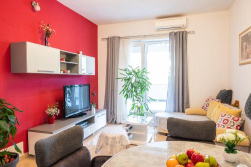 a living room with red walls and a table at Four Hills Apartment in Žrnovnica
