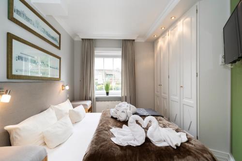 a hotel room with swans towels on a bed at Hotel Parkresidenz Christian VIII in Archsum