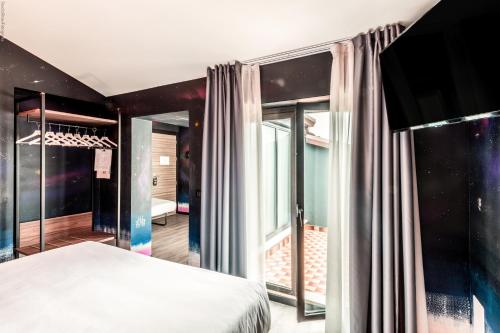 a bedroom with a bed and a large window at Muraless Art Hotel - WorldHotels Crafted in Castel d'Azzano