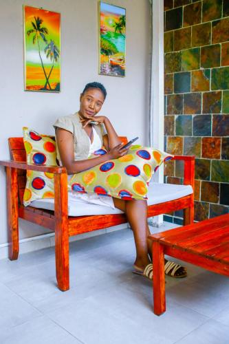 a woman sitting on a bench using a tablet at Eagles Nest Self-Catering Apartments in Gaborone
