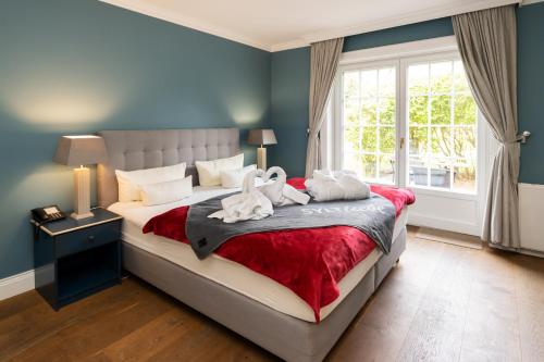 a bedroom with a bed with two stuffed animals on it at Hotel Parkresidenz Christian VIII in Archsum