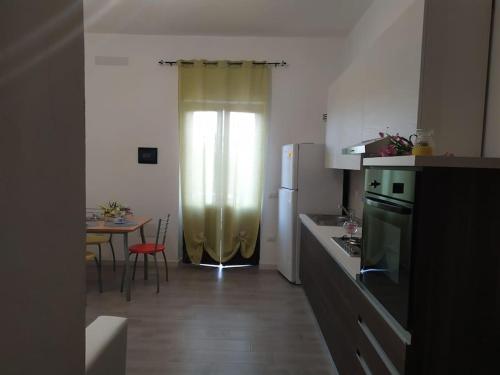 a kitchen with a refrigerator and a table with chairs at Civico 28 in Badesi