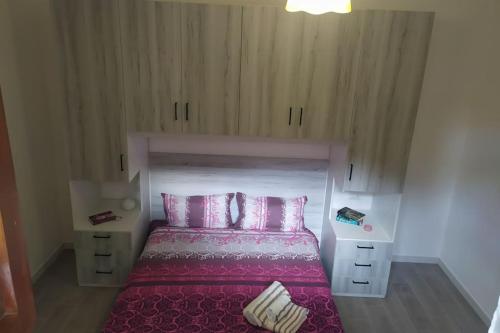a bedroom with a bed with pink sheets and pillows at Civico 28 in Badesi