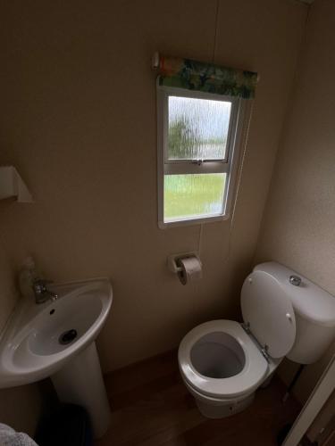 a bathroom with a sink and a toilet and a window at Autocamp Free Star - Mobilheimy in Strachotín