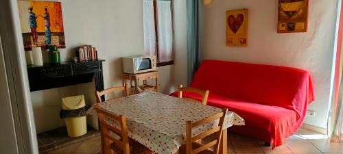 un soggiorno con divano rosso e tavolo di OLMETA DI TUDA - T3 a Olmeta-di-Tuda