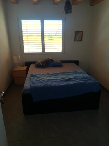 a bedroom with a bed and a window with blinds at BnB Kanal 17 in Lausen