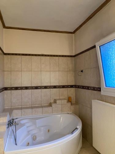 a white bath tub in a bathroom with a window at VILLA MARIA in Kanálion
