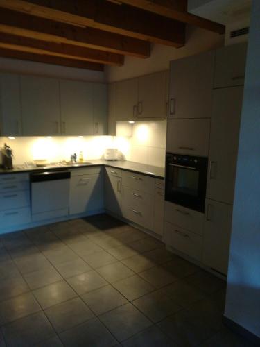 una cocina vacía con armarios y electrodomésticos blancos en BnB Kanal 17, 