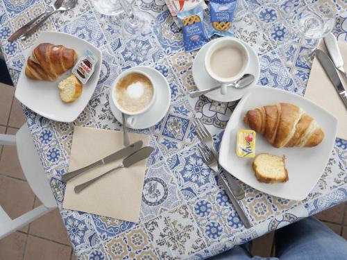 a table with two plates of croissants and a cup of coffee at O Guarracino Rooms in Palinuro