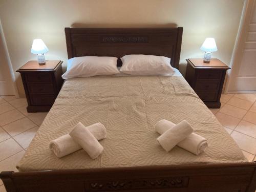 a bed with two pillows on it with two night stands at VILLA MARIA in Kanálion