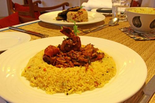 a plate of food on a table with rice at Maison Perumal Pondicherry - A CGH Earth Experience in Puducherry