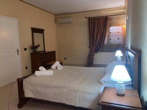 a bedroom with a bed and a table with a lamp at VILLA MARIA in Kanálion