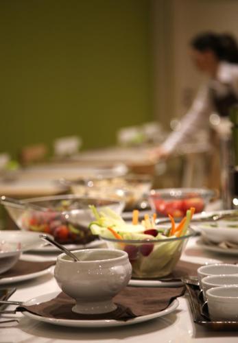 a table topped with bowls and plates of food at Helios Hotel in Monza