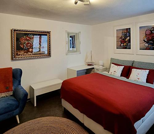 - une chambre avec un lit rouge et une chaise bleue dans l'établissement Apartmán Zlatý kříž, à Písek