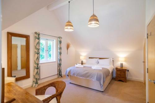 1 dormitorio con cama, mesa y ventana en Trewhiddle Villa 04 en St Austell