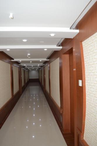 an empty hallway in a building with a white ceiling at Hotel Diamonds Pearl in Visakhapatnam