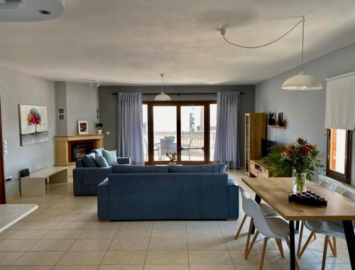 a living room with a blue couch and a table at Anemos Apartment in Keramotí