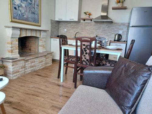 a kitchen with a table and a fireplace at IL TRAMONTO APARTMENT 1 in Kanali