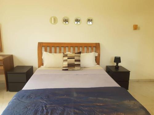 1 dormitorio con 1 cama grande y 2 mesitas de noche en Accra Service villas - villa 2?, en Spintex
