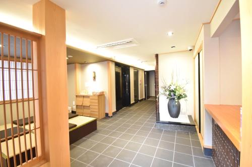 a hallway of a bathroom with a vase of flowers at K-style 東本願寺 in Kyoto