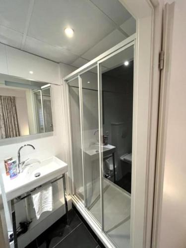 a bathroom with a glass shower and a sink at Residence OLit Cathédrale in Strasbourg