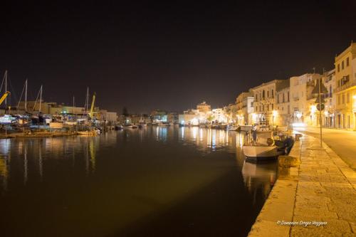 a city at night with boats in the water at Casa Dalfea in Mazara del Vallo