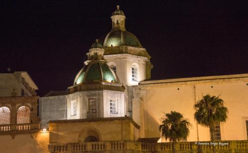a building with a clock tower at night at Casa Dalfea in Mazara del Vallo