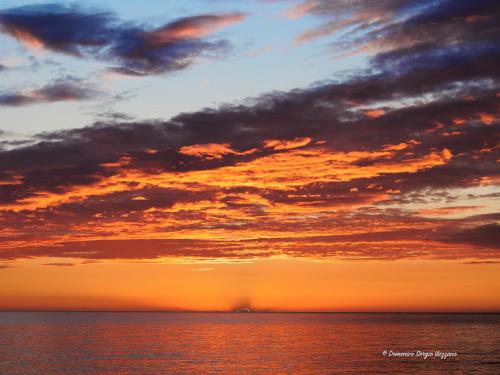 a sunset over the ocean with a cloudy sky at Casa Dalfea in Mazara del Vallo