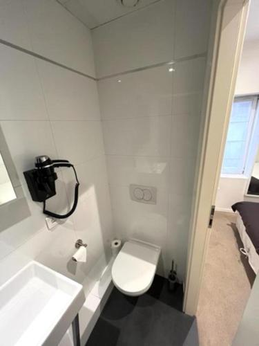 a white bathroom with a toilet and a sink at Residence OLit Cathédrale in Strasbourg
