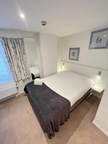 a white bedroom with a bed and a window at Residence OLit Cathédrale in Strasbourg